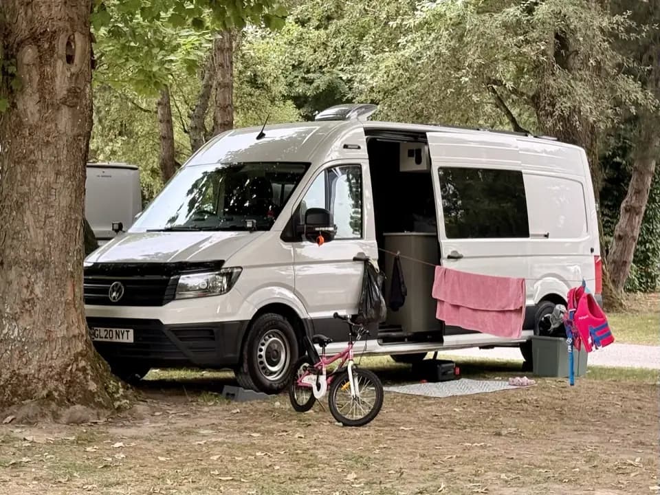 VW Crafter campervan parked under trees